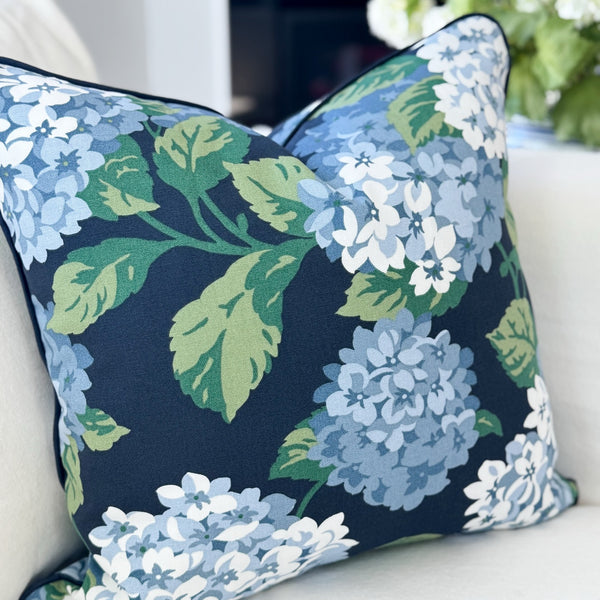 Floral-patterned pillow on a white couch with a blurred background