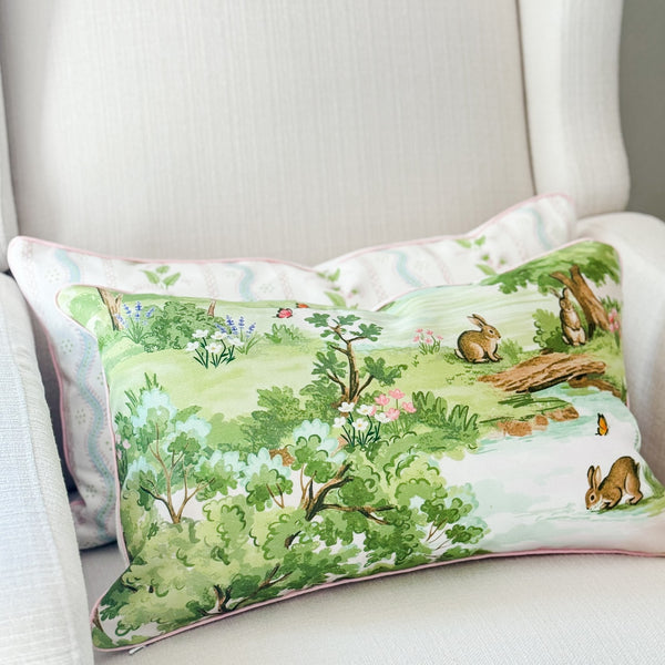 Decorative pillow with nature-themed design featuring animals and plants on a white chair.