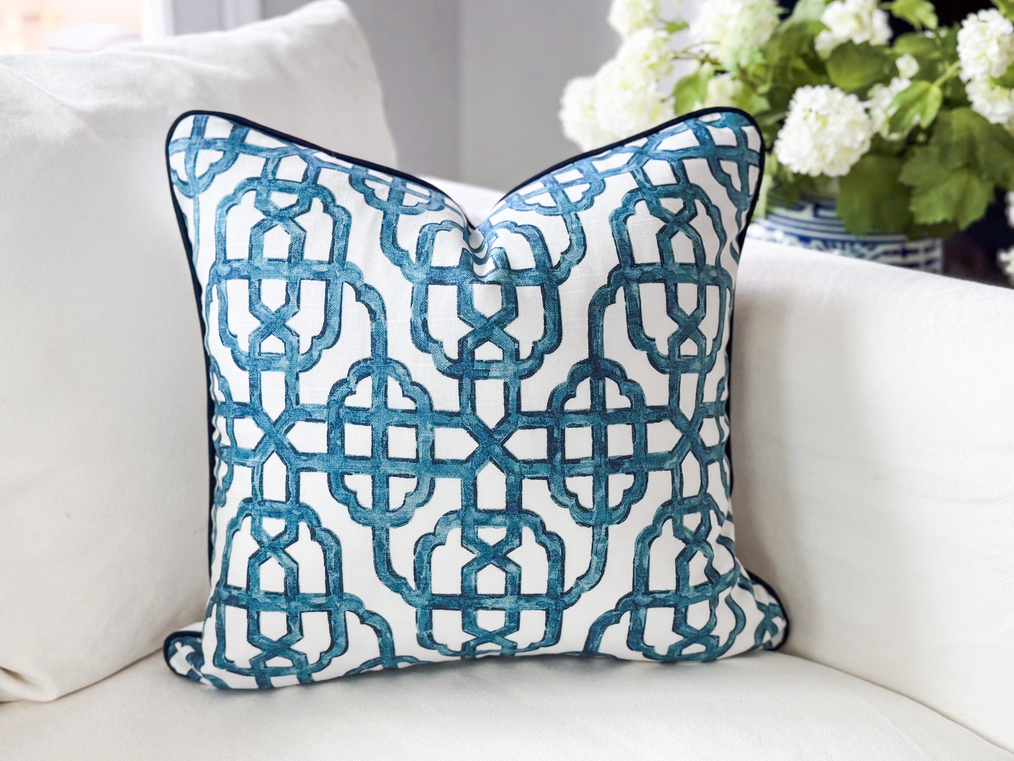 Decorative pillow with blue geometric pattern on a white couch