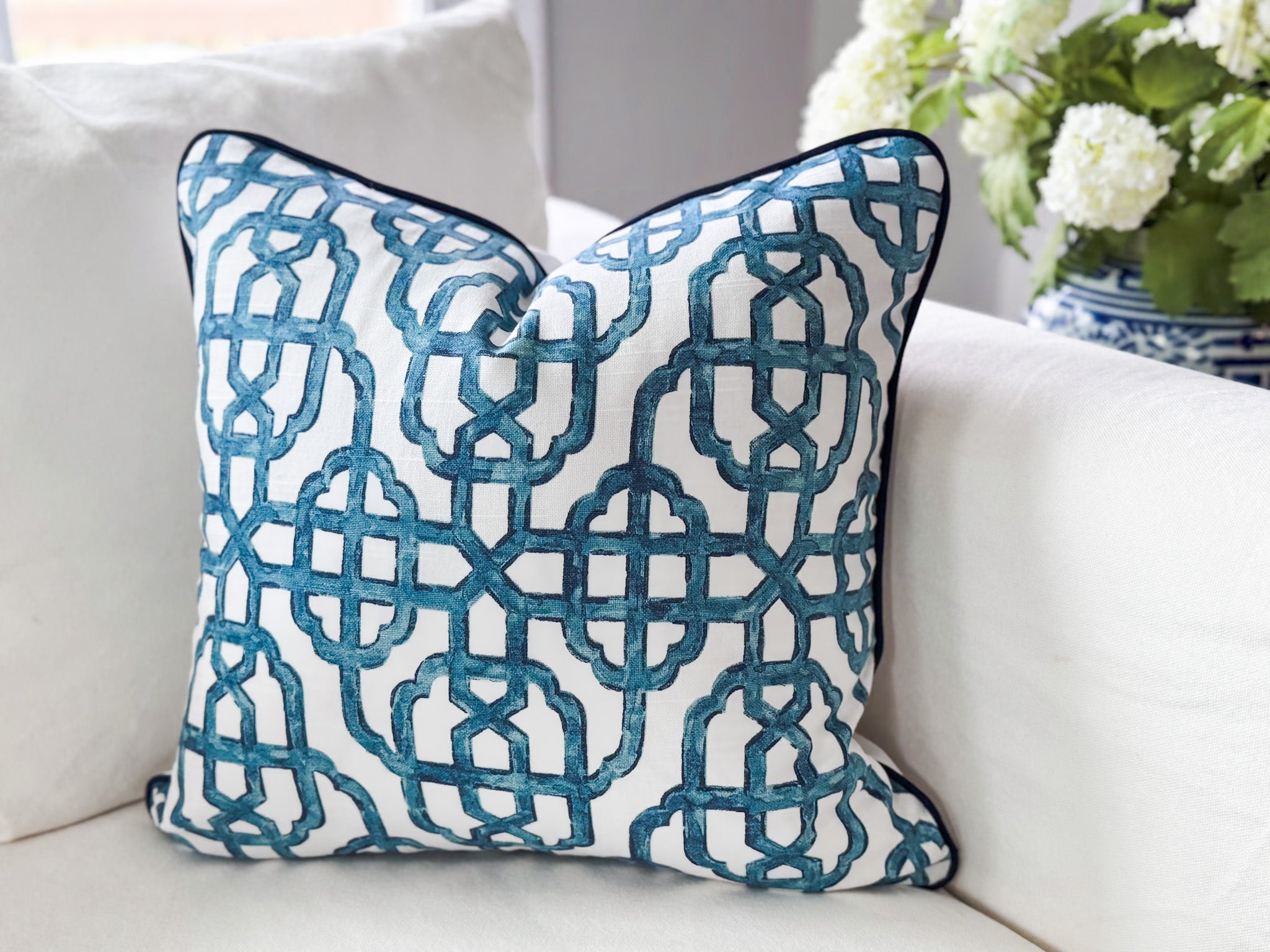 Decorative pillow with blue geometric pattern on a white couch