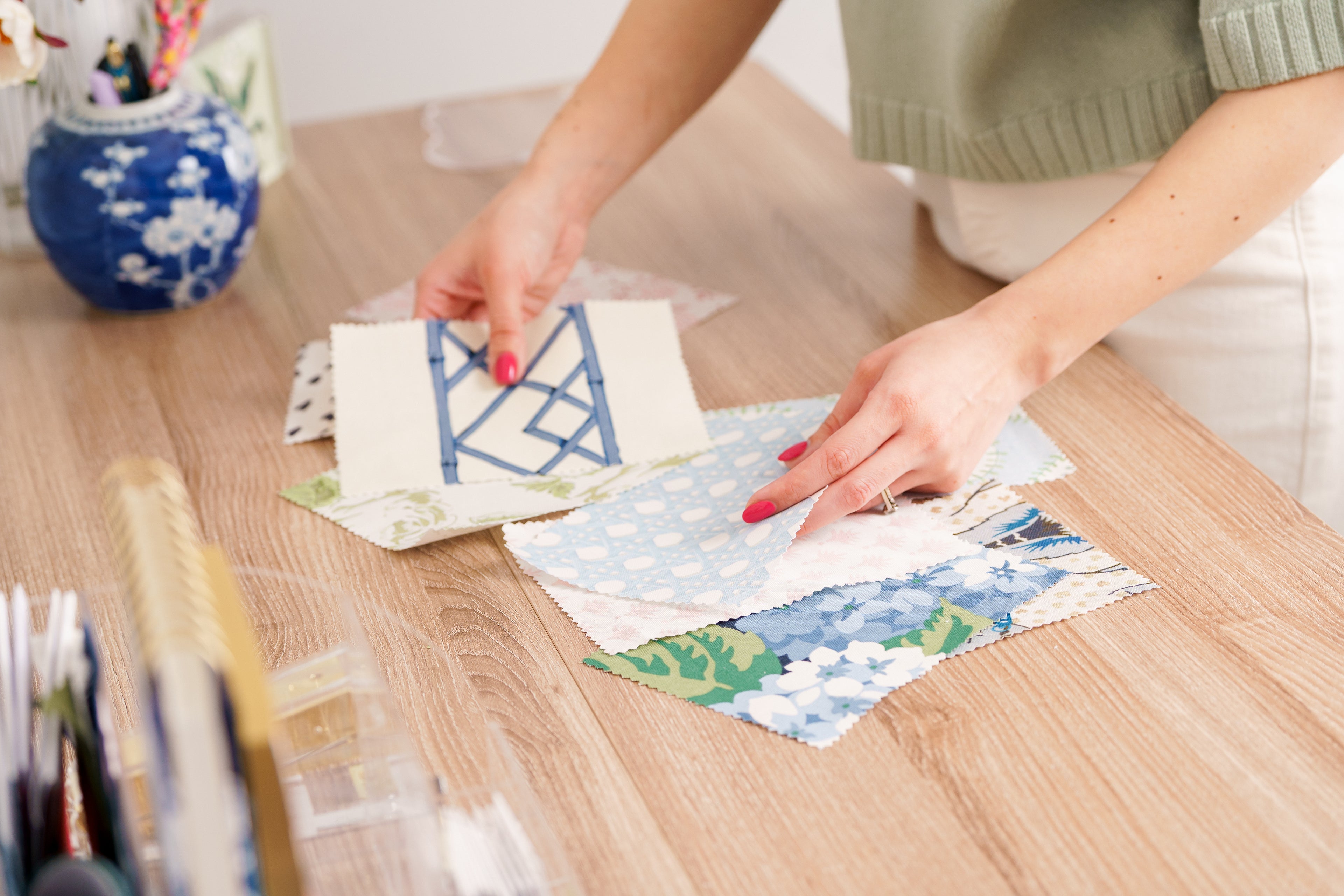 Person arranging fabric samples on a wooden table