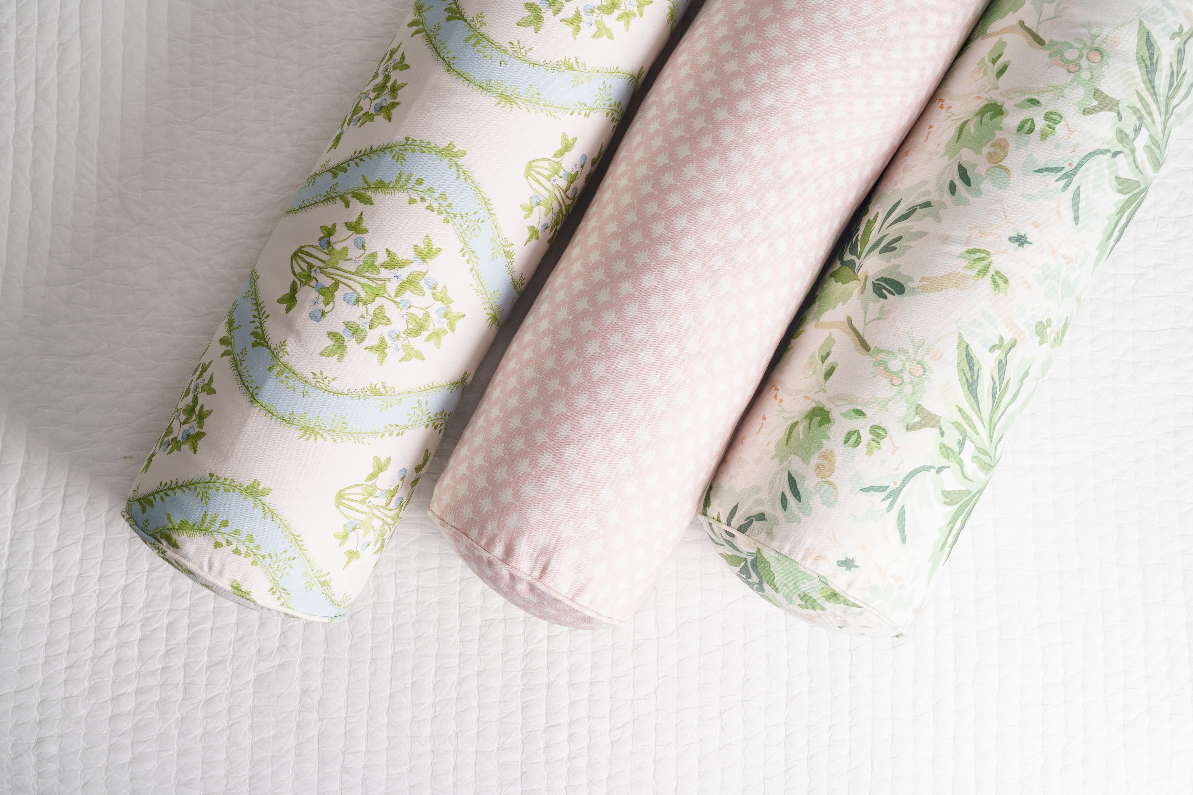 Three fabric rolls with floral patterns on a white background